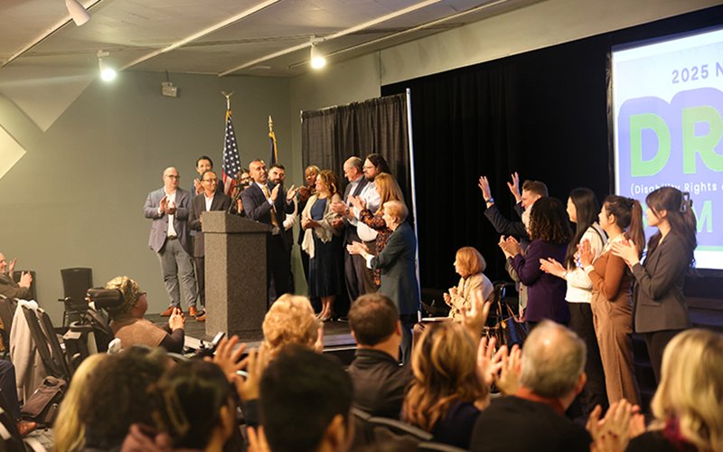 Sanjay Goel on stage at the DREAM Conference, surrounded by other participants in the conference.
