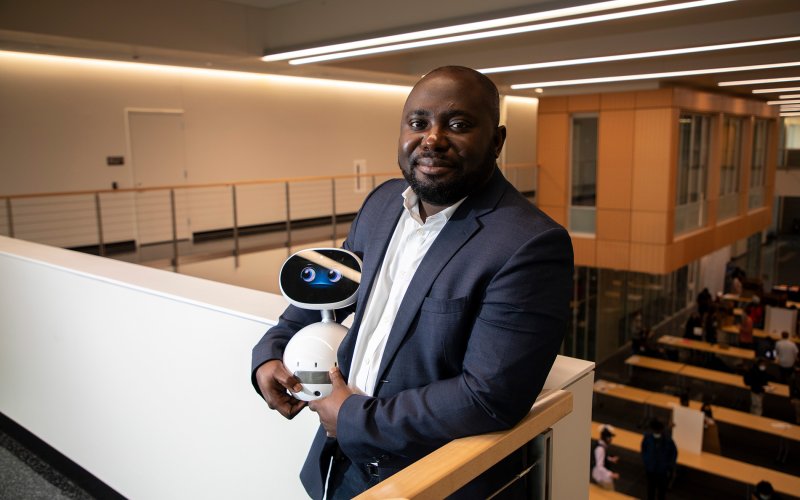 CEHC Benjamin Yankson holds a robot at the new ETEC building.