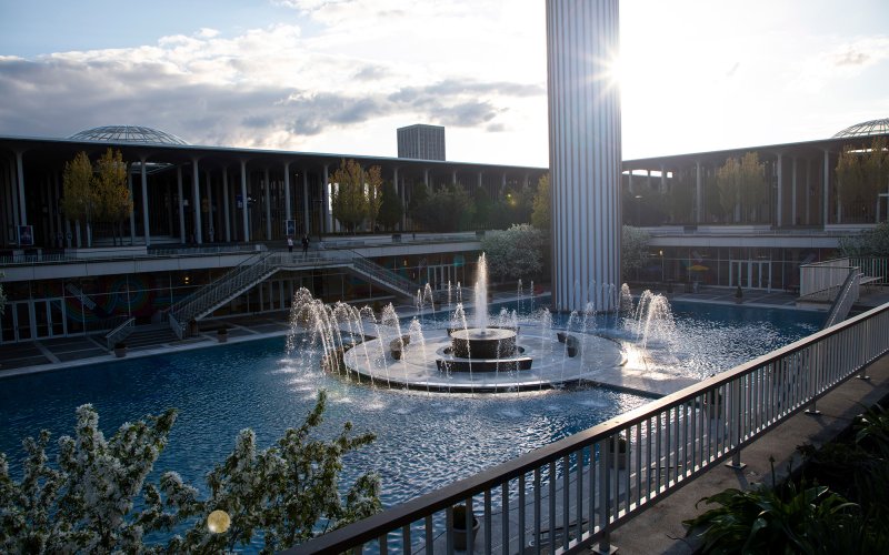 The fountain at the UAlbany Academic Podium under a clear blue sky on a sunny day.
