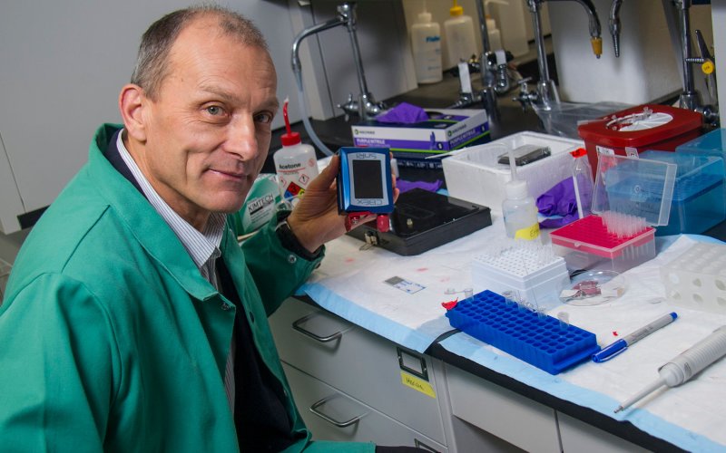 Igor Lednev holds a portable Raman spectrometer.