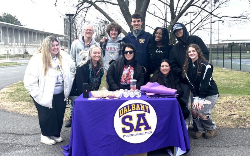 Student Association students huddle around a table.