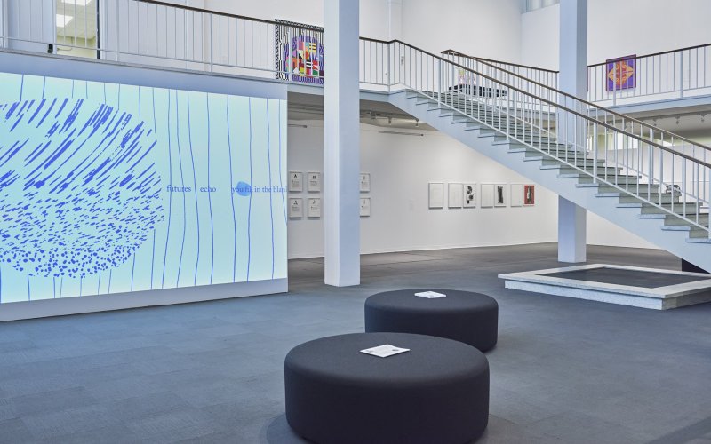 A graphic art piece is projected onto a wall in the UAlbany Museum space.