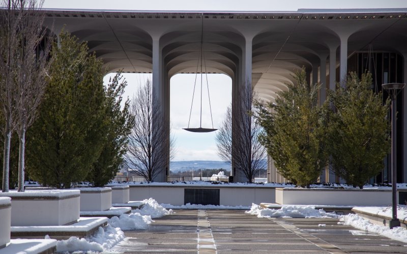 The UAlbany's uptown campus podium with some piles of snow left over from plowing. Low mountains can be seen in the distance