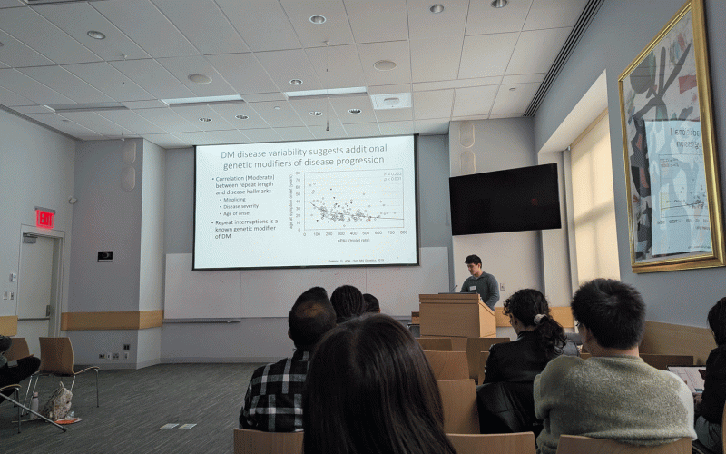 Nick Lane addresses an audience in a lecture room, discussing genetic modifiers of disease progression. A detailed slide with graphs and text is visible.