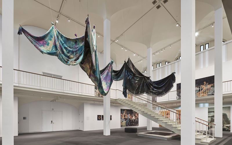 Large shrouds hanging from the ceiling of the museum.