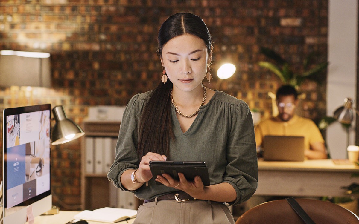 A social media manager works on a tablet in an office.