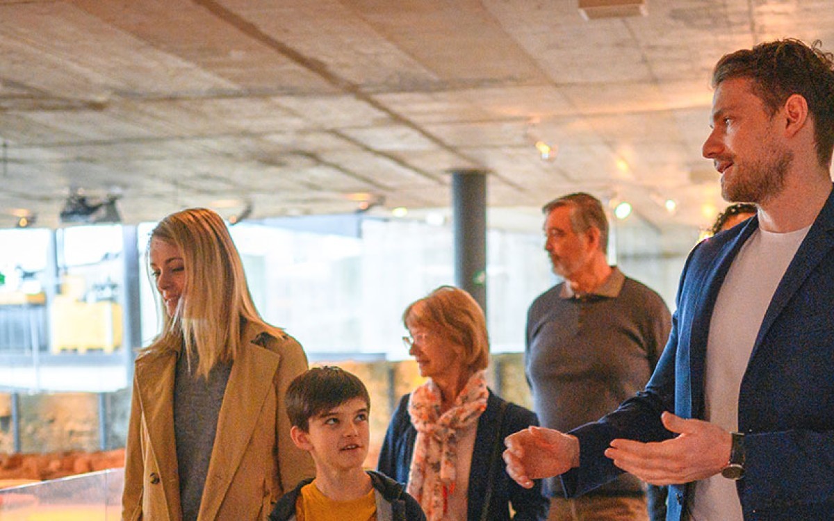 A historian leads a group through a museum exhibit.