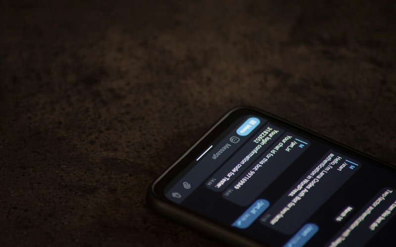 A phone is open on a brown surface with a chatbot conversation on the screen.