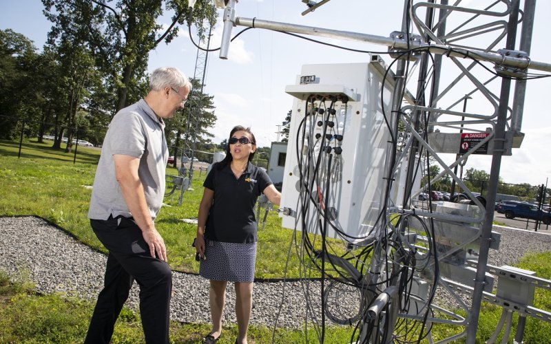 Chris Thorncroft and June Wang look at Mesonet instrumentation from inside the ETEC yard.