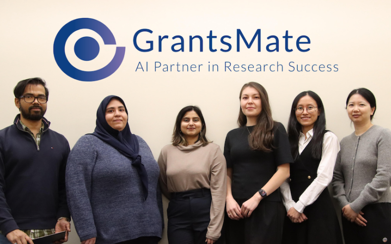 Six people stand in a row beneath the GrantsMate logo with the tagline "AI Partner in Research Success" on a plain white background.