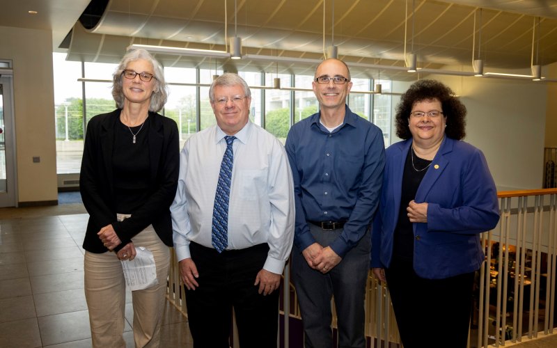 UAlbany faculty Elaine Salisbury, Kevin Knuth and Ryan Torn stand with College of Arts and Sciences Dean Jeanette Altarriba indoors.