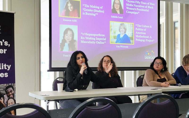 A panel of women are seated indoors speaking about their women's, gender and sexuality studies final projects during Showcase 2026 at UAlbany.