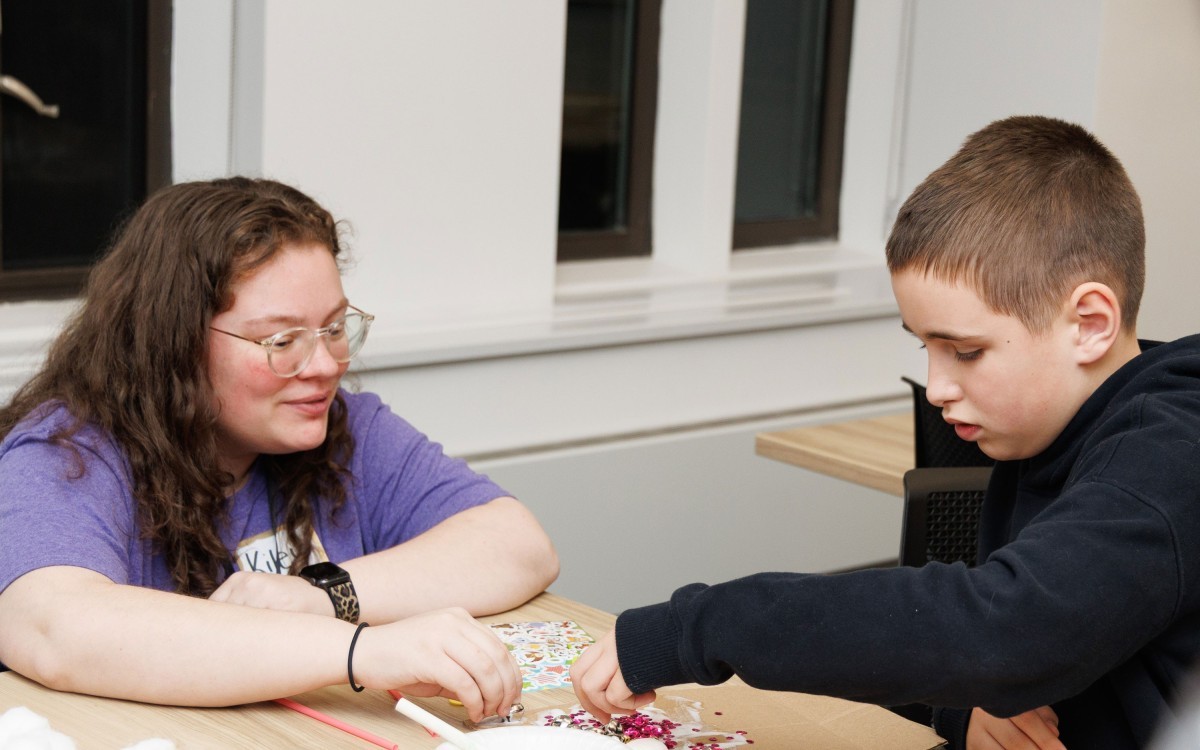 An individual working on a project with a younger child.