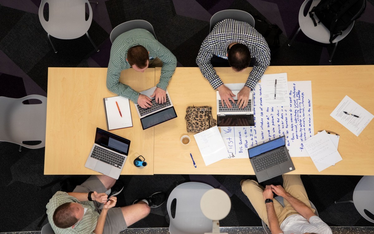 Students at a table with their laptops