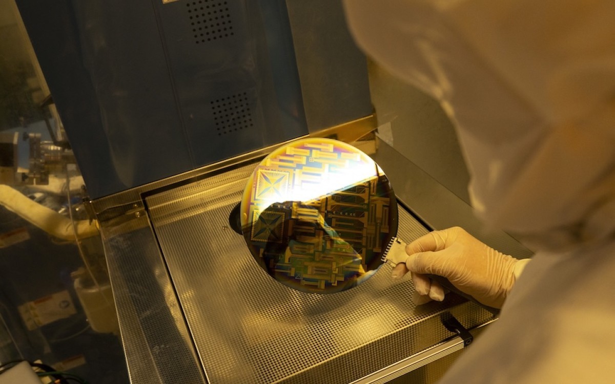 A person in white PPE demonstrates a new state-of-the-art chip design tool.