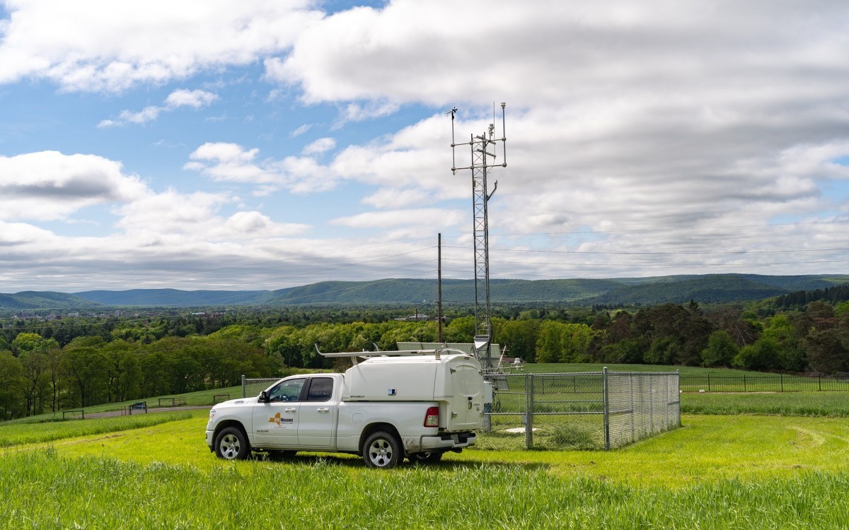 A NYS Mesonet truck sits in front of a site in the Adirondacks.
