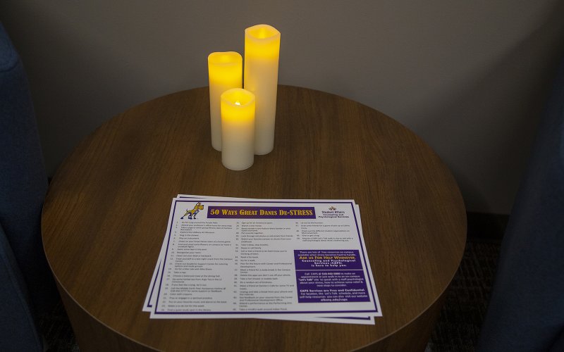 Three lit candles with handout on how students can de-stress.