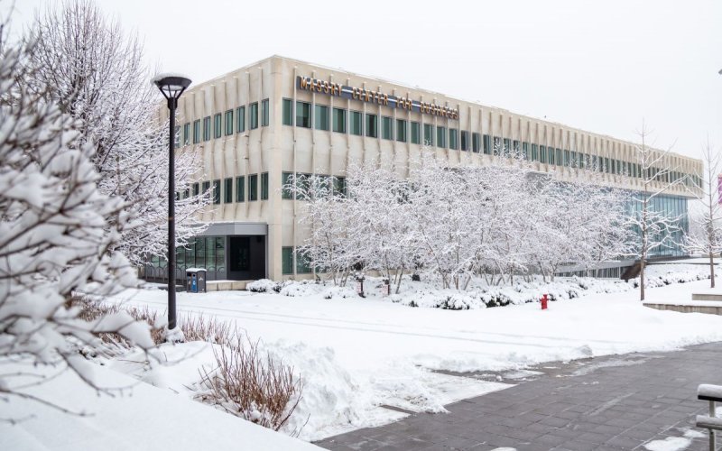 The Massry Center for Business with snow-covered trees and walkways