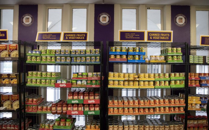 Cans of food fill shelves at a campus food pantry