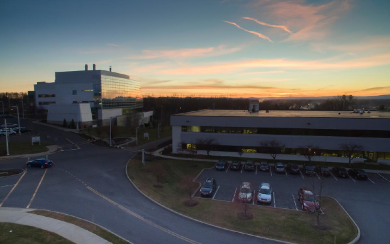 The Health Sciences Campus is backlit by a blue, yellow, and orange sunset.