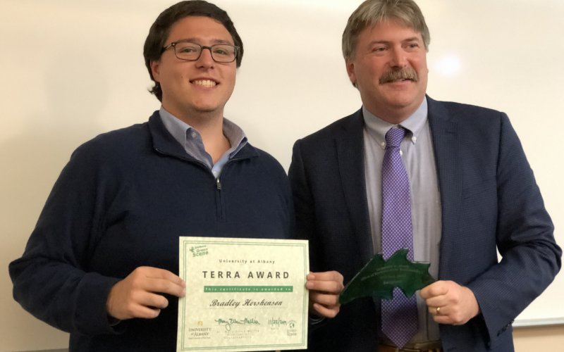 Bradley Hershenson holds up his Terra Award with VP for Finance and Administration Todd Foreman