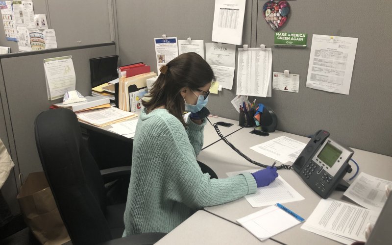SPH student Makensy Jabbour talks on the phone at her desk at the Albany County Department of Health, where she interned.