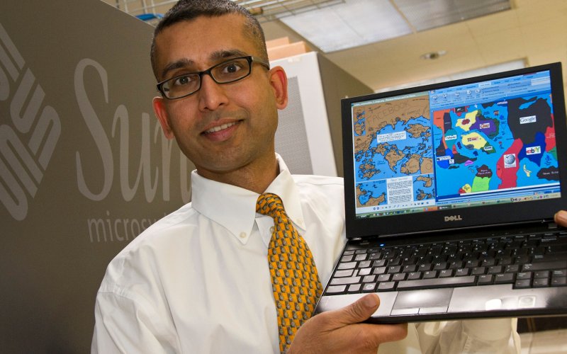 Sanjay Goel holding laptop