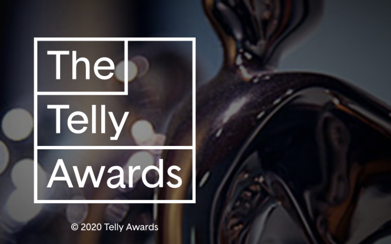 "The Telly Awards" is written in white on top of a dark background image of a dim gold trophy.