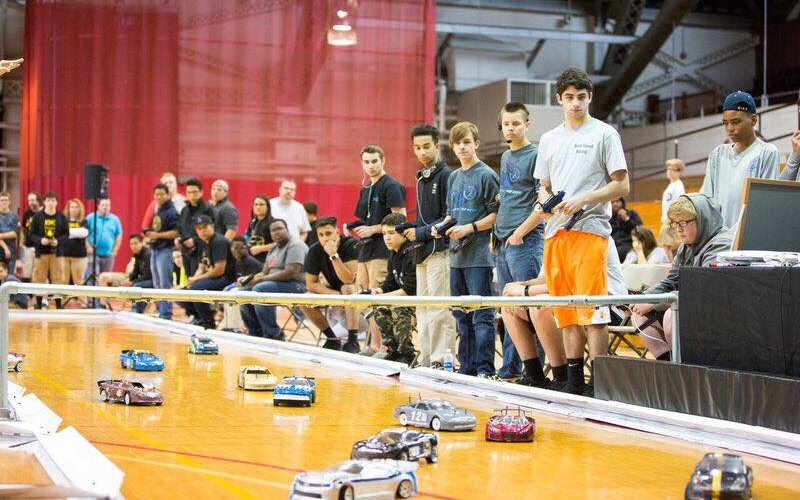 Students race RC cars around gynmasium during Ten80 competition.