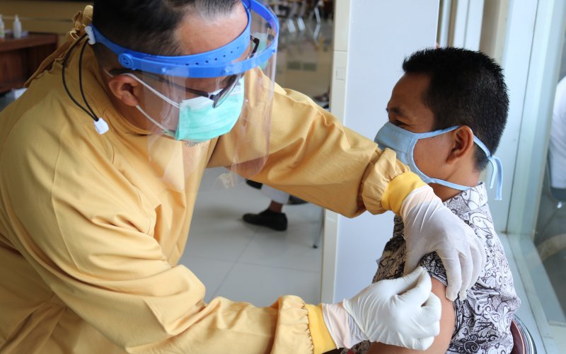 A health professional administers a COVID-19 vaccine to an individual.