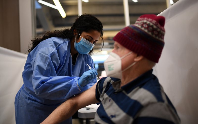 A volunteer delivers a vaccine dose to a New York State Resident at the Vaccine POD at Yankee Stadium in the Bronx.