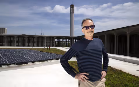 ASRC Senior Research Associate Richard Perez observes an array of 90 LG 350-watt solar panels installed on the Campus Center West addition roof.