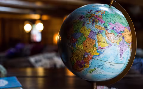 A globe sits on a shiny brown desk