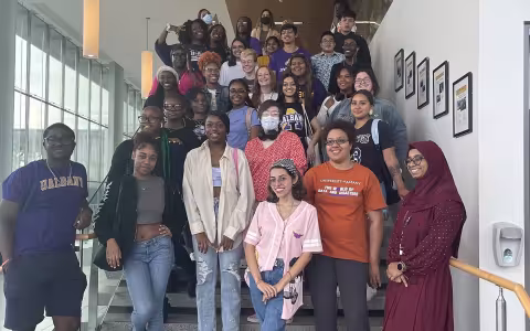 A group of about 40 student educators pose on a staircase.