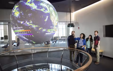 DAES faculty and students observe the "Science on a Sphere" globe inside ETEC.