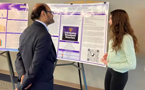 Spanish TA and PhD student Caitlin Fanning presents a research poster to the U's VP for Research & Economic Development
