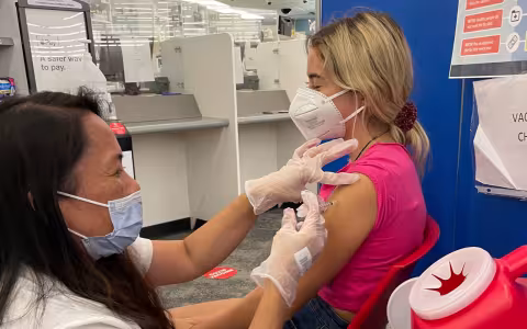 A child sits in a chair to receive a Covid-19 vaccine. 