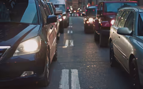 Six cars sit bumper to bumper on a road.