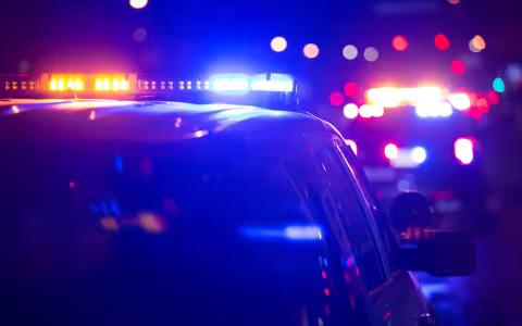 A police car's lights are on in the dark.
