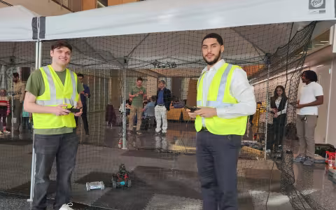 CEHC students Jay Parker and Hadley Santos control drones and robotics in the pop up tent at ETEC.