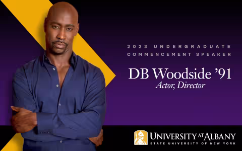 DB Woodside in a blue button-down shirt with the words 2023 undergraduate commencement speaker, University at Albany