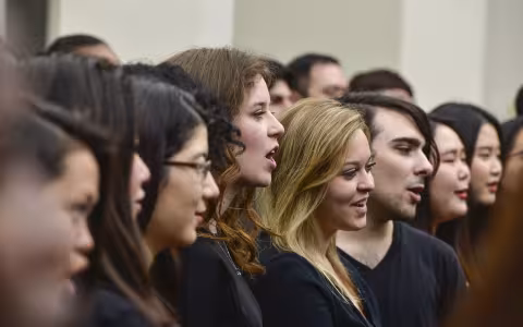 large number of performers sing in a line