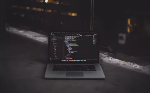 A laptop stands alone and displays lines of malicious code.