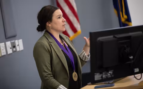 Dr. Jetelina wears the Axelrod Prize medal and stands at the podium to give her lecture.
