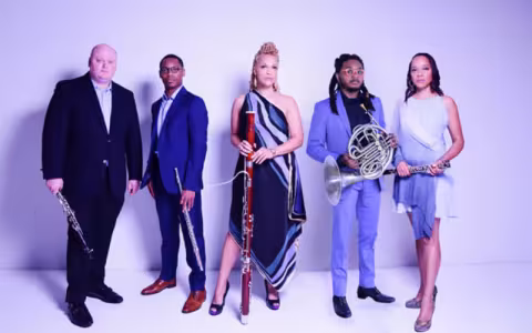 Five musicians pose with their instruments on a purple background