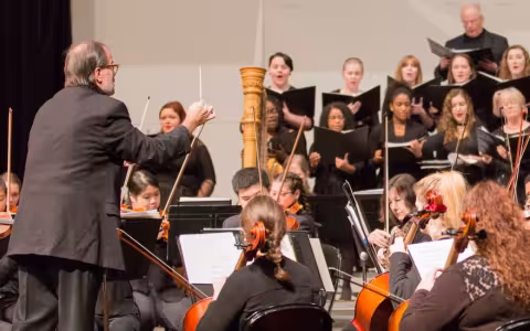 Various musicians sing and play instruments on stage in concert