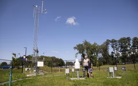 Chris Thorncroft and June Wang point at instrumentation at the NYS Mesonet's ETEC site.