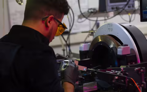 Nanoscale engineering student Kevin Reyes works on a machine at the College of Nanotechnology, Science, and Engineering. (Photo by Brian Busher)
