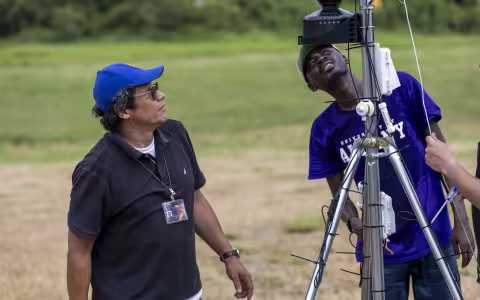 Jorge Gonzalez-Cruz works with a UAlbany student to install a specialized sensor that can monitor Puerto Rico's transmission towers.