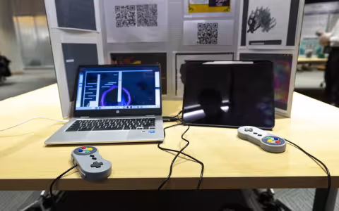 Laptops connecting to gaming controllers sit on a table inside the ETEC shared training room.